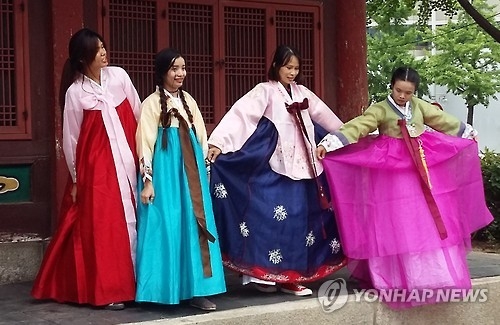 Foreign travelers show off their hanbok during their visit to a traditional village in Seoul on July 3, 2016. (Yonhap)