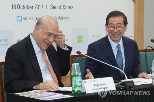 Angel Gurria (L), Secretary-General of the Organization for Economic Cooperation and Development, smiles during a joint press conference with Seoul Mayor Park Won-soon (R) held in the capital city of South Korea on Oct. 18, 2017. (Yonhap)