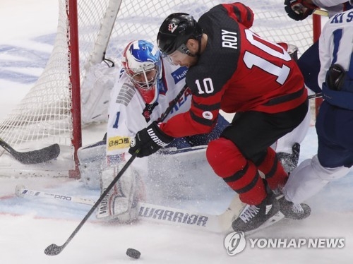 In this Reuters photo, South Korean goalie Matt Dalton (L) stops Derek Roy of Canada during the teams' Channel One Cup game at VTB Ice Palace in Moscow on Dec. 13, 2017. (Yonhap)