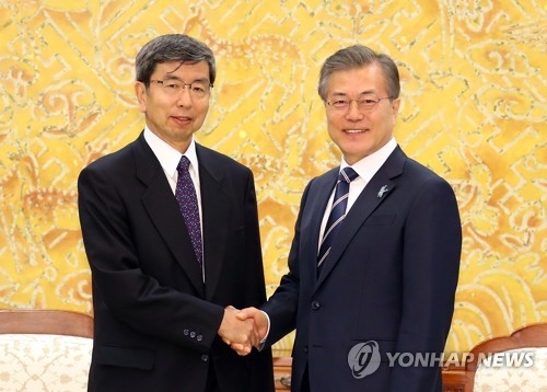 South Korean President Moon Jae-in (R) shakes hands with ADB President Takehiko Nakao before the start of their meeting at his office Cheong Wa Dae in Seoul on March 14, 2018. (Yonhap)