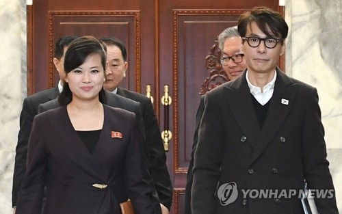 This photo, provided by South Korea's unification ministry on March 20, 2018, shows Yoon Sang (R), a South Korean composer and the chief delegate for inter-Korean talks on a South Korean art troupe's planned performance in Pyongyang, and his North Korean counterpart Hyon Song-wol (L), entering a conference room at the Tongilgak administrative building on the northern side of the truce village of Panmunjom. (Yonhap)