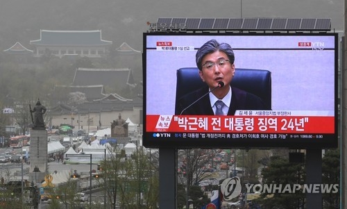 This photo, taken from a long shot in central Gwanghwamun, captures the moment in a live televised corruption trial of former President Park Geun-hye on April 6, 2018, that the judge metes out a 24-year prison sentence for the disgraced leader. (Yonhap) 