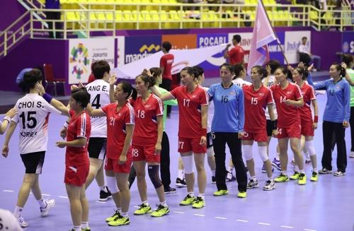 Players on the South Korean (white) and North Korean women's handball teams high-five each other before the start of their preliminary match at the Asian Games at GOR Popki Cibubur in Jakarta on Aug. 14, 2018. (Yonhap)