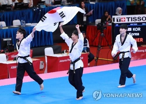 Members of the South Korean men's taekwondo poomsae team celebrate their gold medal at the 18th Asian Games at Jakarta Convention Center (JCC) Plenary Hall in Jakarta on Aug. 19, 2018. (Yonhap)