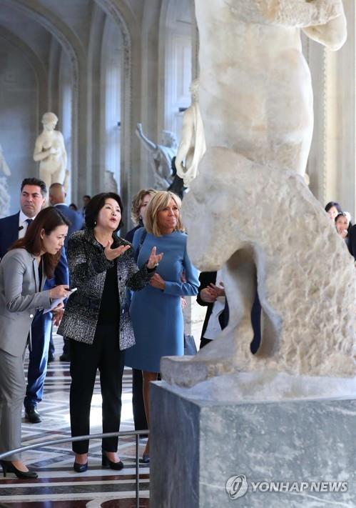 South Korean First Lady Kim Jung-sook looks at an artifact with her French counterpart, Brigitte Macron, at the Louvre Museum in Paris on Oct. 15, 2018. (Yonhap) 