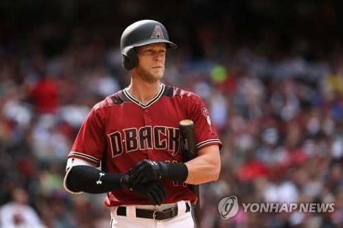 In this Getty Images file photo from April 9, 2017, Jeremy Hazelbaker, then with the Arizona Diamondbacks, adjusts his batting gloves during a Major League Baseball regular season game against the Cleveland Indians at Chase Field in Phoenix, Arizona. South Korean ball club Kia Tigers said that they've acquired Hazelbaker on a one-year, US$700,000 million deal. (Yonhap)