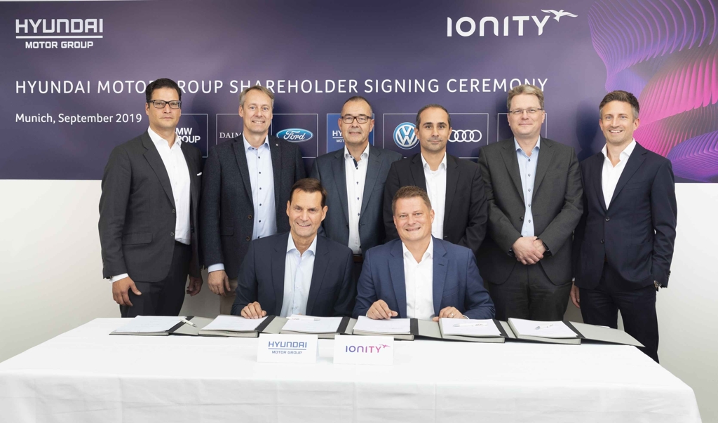 In this photo provided by Hyundai Motor Group, Thomas Schemera (front row, L), Executive Vice President at Hyundai Motor Group, and IONITY CEO Michael Hajesch (front row, R) pose for a photo with officials from BMW, Ford, Mercedes-Benz and Porsche after signing a strategic partnership agreement at IONITY's headquarters in Munich, Germany, on Sept. 6, 2019. (PHOTO NOT FOR SALE) (Yonhap)