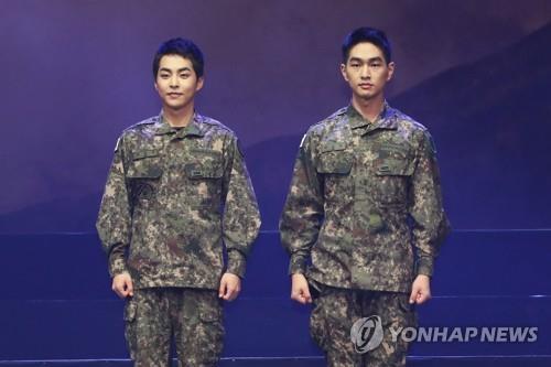 EXO's Xiumin (L) and SHINee's Onew pose for photos during a press showcase of a military musical, "Return: The Promise of the Day," on Sept. 24, 2019. (Yonhap)