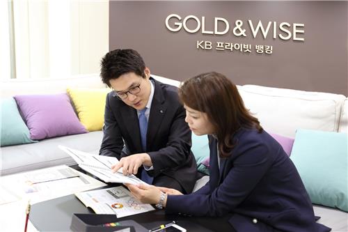 This undated photo provided by KB Kookmin Bank shows a private banker (L) explaining a financial product to a customer in a meeting room of the bank's private banking center in Myeongdong, central Seoul. (PHOTO NOT FOR SALE) (Yonhap)