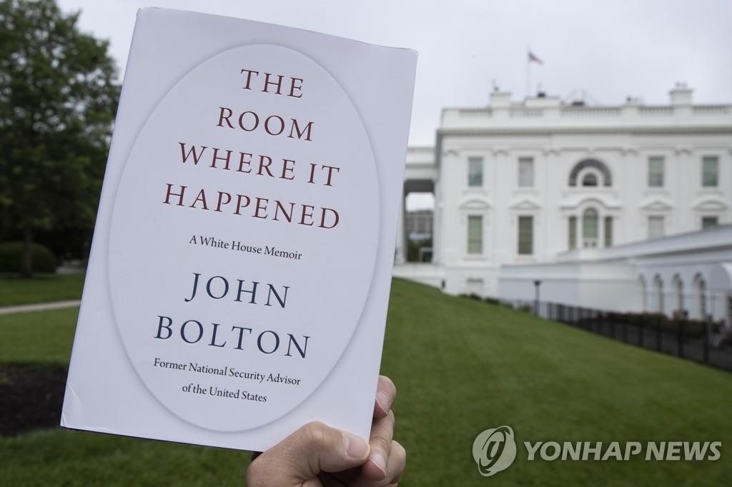 A copy of former U.S. National Security Advisor John Bolton's memoir, "The Room Where It Happened," is seen against the backdrop of the White House in Washington on June 18, 2020, in this photo released by the Associated Press. (Yonhap)