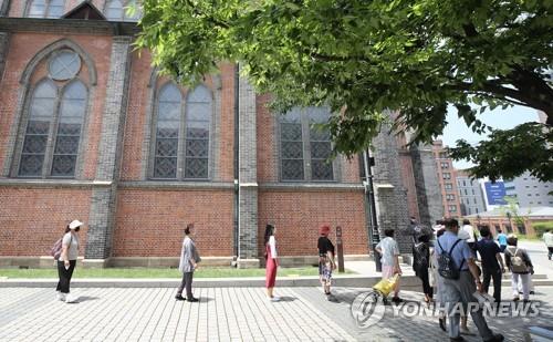 People keep distance from one another while waiting in line for Mass at Myeongdong Cathedral in central Seoul on June 28, 2020. (Yonhap)