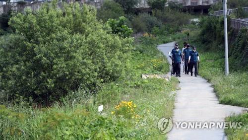 Police officers search a trail along a stream for a man in his 60s in the southwestern city of Gwangju on July 7, 2020, after he was confirmed to have been infected with the new coronavirus and went into hiding with his smartphone turned off. (Yonhap)