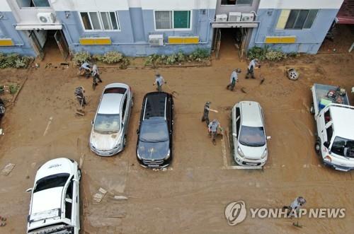 Army soldiers and volunteers engage in restoration work at a flooded apartment complex in Daejeon, central South Korea, on July 31, 2020. (Yonhap)