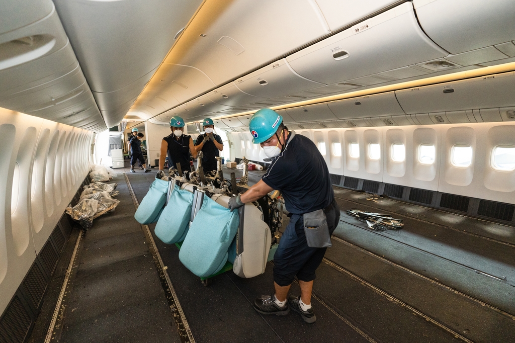 This file photo provided by Korean Air shows employees removing seats on a B777-300ER jet to convert it into a cargo plane. (PHOTO NOT FOR SALE) (Yonhap)