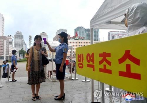 This photo, released by the North's Korean Central News Agency on Aug. 29, 2020, shows an official taking a citizen's temperature at Pyongyang Station in the capital to prevent the outbreak of the coronavirus. (For Use Only in the Republic of Korea. No Redistribution) (Yonhap)