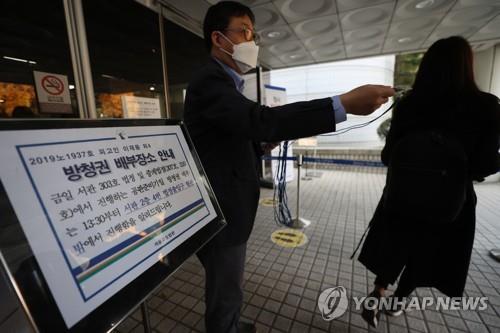 Spectators receive a ticket for the retrial of Lee Jae-yong, vice chairman of Samsung Electronics Co, in front of the Seoul High Court on Oct. 26, 2020. (Yonhap)