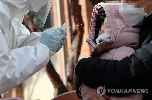 A medical worker conducts a coronavirus test on a child at an elementary school in the central city of Daejeon on Nov. 28, 2020. (Yonhap)