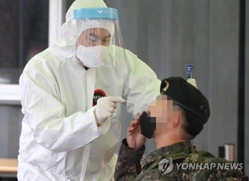 A service member undergoes a COVID-19 test at a makeshift testing facility in central Seoul on March 1, 2021. (Yonhap)