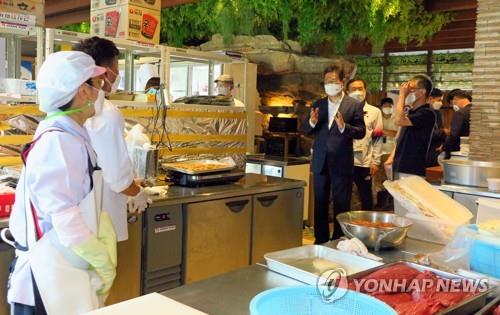 South Korean Minister of Culture, Sports and Tourism Hwang Hee (C) visits a South Korean meal service center in Tokyo on July 24, 2021, in this photo provided by the Korean Culture Center in Japan. (PHOTO NOT FOR SALE) (Yonhap)