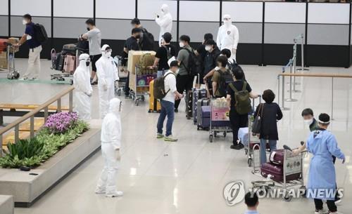 In the July 13, 2021, file photo, South Korean residents and diplomats from India are guided by quarantine officials upon their arrival at Incheon International Airport, west of Seoul, amid the fourth wave of COVID-19. (Yonhap)