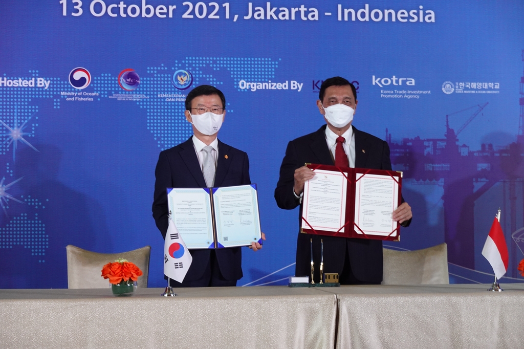 South Korea's Oceans and Fisheries Minister Moon Seong-hyeok (L) and his Indonesian counterpart, Luhut Binsar Pandjaitan, pose for photos after clinching a memorandum of understanding on offshore plant industry cooperation in Jakarta on Oct. 13, 2021, in this photo provided by Moon's office. (PHOTO NOT FOR SALE) (Yonhap) 