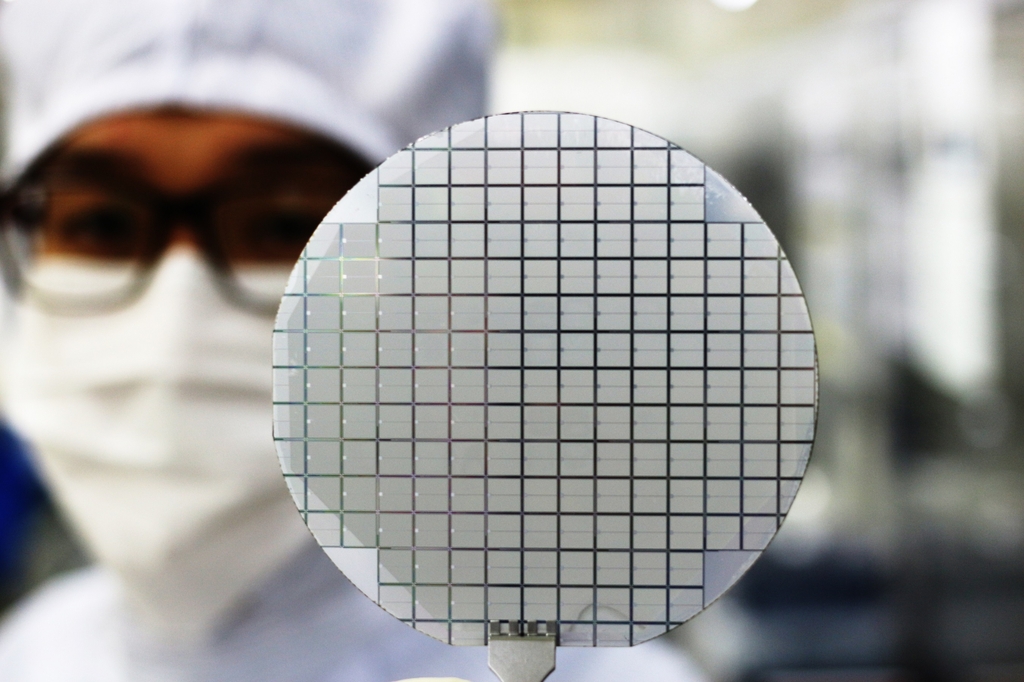 An official from Yes Power Technix shows a semiconductor wafer in this photo provided by SK Inc. on April 27, 2022. (PHOTO NOT FOR SALE) (Yonhap) 