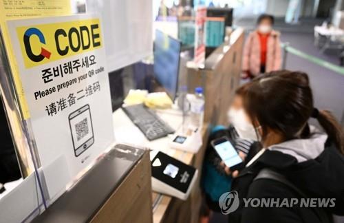 Travelers wait to have their QR code checked for COVID-19 prevention efforts at Incheon International Airport, west of Seoul, on Jan. 5, 2023, as South Korea implemented a mandatory quarantine information registration system for entrants from China, Hong Kong and Macao. (pool photo) (Yonhap)