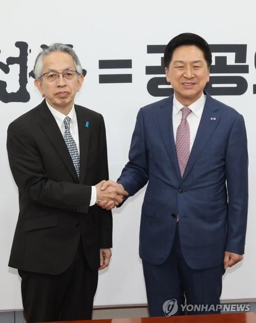 Rep. Kim Gi-hyeon (R), the leader of the ruling People Power Party, shakes hands with the Japanese Ambassador to South Korea, Koichi Aiboshi, at the National Assembly on June 8, 2023. (Yonhap)
