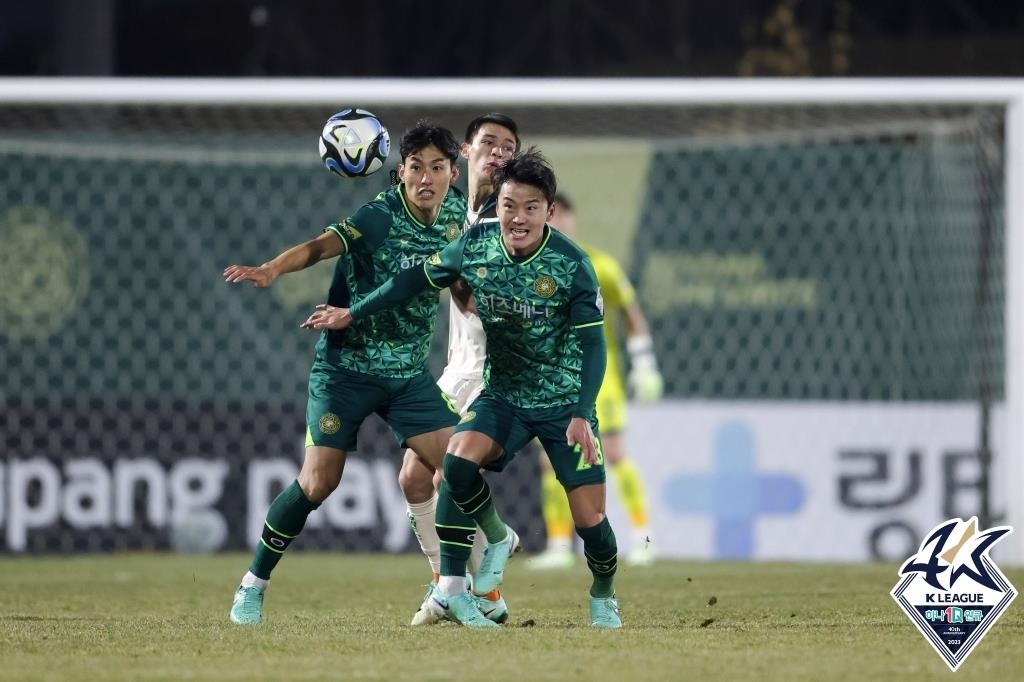 Ikromjon Alibaev of Gangwon FC (C) is sandwiched by Kim Yi-seok (L) and Choi Jae-hun of Gimpo FC during the opening leg of the K League promotion-relegation playoffs at Gimpo Solteo Football Field in Gimpo, Gyeonggi Province, on Dec. 6, 2023, in this photo provided by the Korea Professional Football League. (PHOTO NOT FOR SALE) (Yonhap)