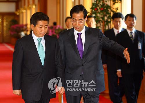 Le défunt président Roh Moo-hyun et le Premier ministre de l'époque Han Duck-soo discutent avant de participer à une réunion des ministres à Cheong Wa Dae en avril 2007. (Photo d'archives Yonhap)