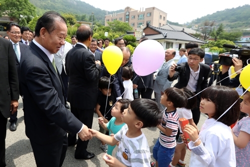 共生園を訪問した二階氏が子どもたちと握手している＝１１日、木浦（聯合ニュース）