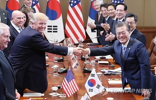 会談で握手を交わす文大統領（右）とトランプ大統領＝７日、ソウル（聯合ニュース）