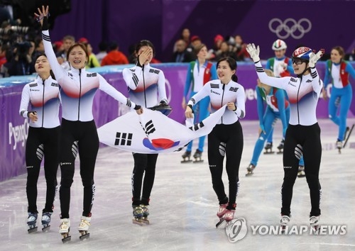 競技を終え、韓国国旗を手に観客の声援に応える韓国選手＝２０日、江陵（聯合ニュース）
