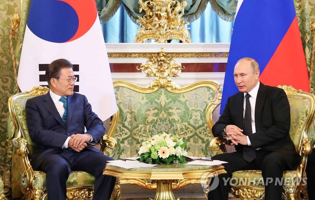 会談を行う文大統領（左）とプーチン大統領＝２２日、モスクワ（聯合ニュース）