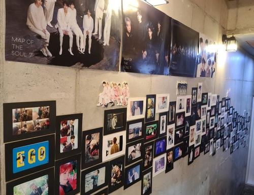 カフェの壁に飾られたメンバーの写真＝１７日、蔚山（聯合ニュース）