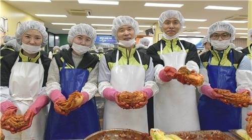 김해준 교보증권 대표(가운데)가 직접 담근 김치를 들고 포즈를 취하고 있다.