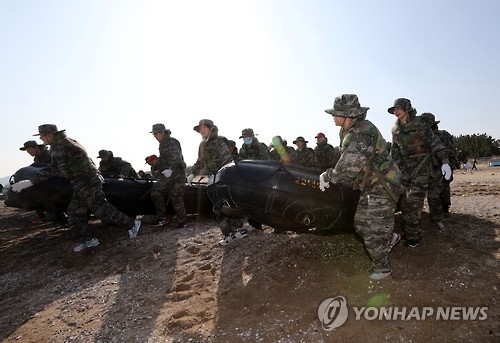 (포항=연합뉴스) 김준범 기자 = 12일 경북 포항시 남구 도구해수욕장에서 열린 '2017년 겨울 해병대 캠프'에서 참가자들이 고무보트를 들고 바다로 뛰어들고 있다. 2017.1.12