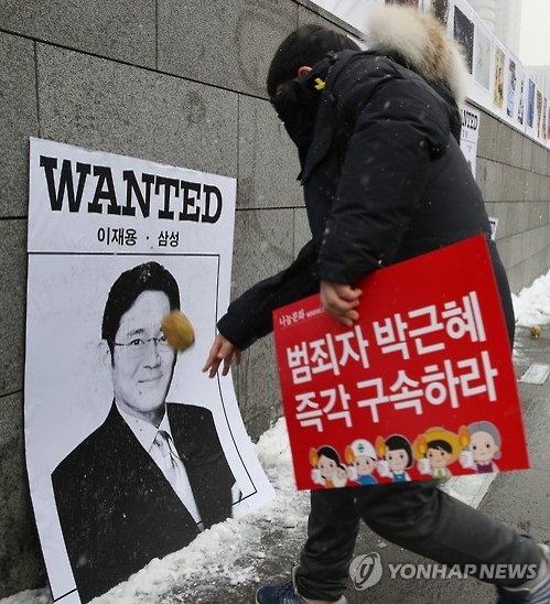 '이재용 현상수배'(서울=연합뉴스) 임헌정 기자 = 박근혜정권퇴진 비상국민행동의 13차 촛불집회가 예정된 21일 오후 서울 종로구 광화문 광장에서 시민들이 이재용 삼성전자 부회장과 우병우 전 청와대 민정수석, 경찰 지휘부 등을 현상수배범으로 풍자한 그림을 향해 공을 던지고 있다. 2017.1.21kane@yna.co.kr(끝)