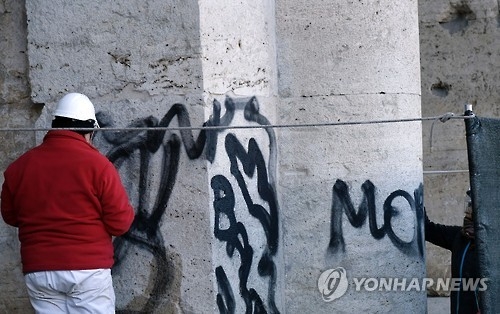 이탈리아 로마의 콜로세움 관리인들이 외벽의 낙서를 지우고 있다.