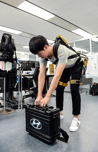 현대기아차 연구원들이 웨어러블 로봇을 착용하고 시연하는 모습