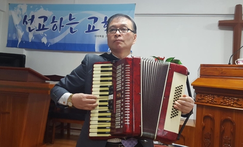 안산 예수마을선교교회의 오학봉 목사가 음대 출신답게 능숙하게 아코디언을 연주하고 있다.