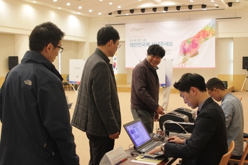 (모스크바=연합뉴스) 러시아 주재 한국 대사관에 차려진 투표소에서 25일(현지시간) 교민들이 투표용지를 받기 위해 줄 서 있다.