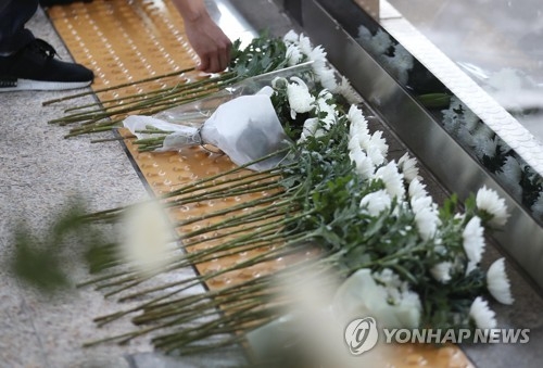 (서울=연합뉴스) 김현태 기자 = 27일 오후 서울지하철 2호선 구의역에서 열린 구의역 스크린도어 사고 1주기 추모 문화제에서 참석자들이 사고현장에 국화꽃을 놓고 있다. 지난해 5월 28일 구의역에서 스크린도어를 혼자 수리하던 외주업체 직원 김모씨는 전동차에 부딪혀 숨졌다. 2017.5.27mtkht@yna.co.kr (끝)