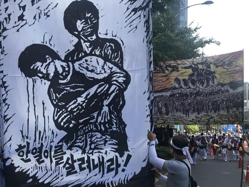 최병수 작가의 '한열이를 살려내라!'와 '노동해방도'를 재현한 대형 걸개 사진.