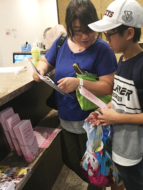 민박집에 기증한 안내서를 보고 있는 관광객 모습