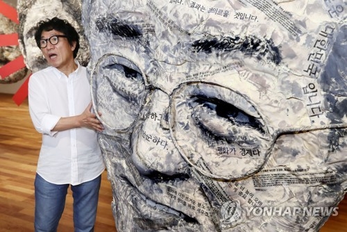 (서울=연합뉴스) 이재희 기자 = 서양화가 임옥상이 22일 오전 서울 종로구 가나아트센터에서 열린 개인전 '바람 일다' 기자간담회에서 '가면무도회' 작품을 설명하고 있다. 2017.8.22 scape@yna.co.kr