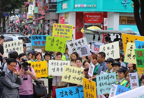 (서울=연합뉴스) 김주성 기자 = 중국동포한마음회, 귀한중국동포권익증진위원회 등 국내 중국동포 단체 회원들이 28일 오후 서울 영등포구 대림역 앞에서 영화 '청년경찰'에서 중국동포와 거주지역인 대림동을 비하하는 장면이 자주 나온다며 상영중단과 사과를 요구하고 있다. 대림동에서 외국인자율방범대원으로 활동하는 중국동포 여성이 피켓을 들고 중국동포에 대한 잘못된 인식을 심어주는 영화상영에 대한 불만을 토로하고 있다.