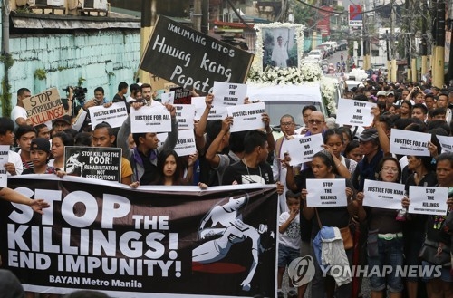 8월 26일 필리핀 마닐라에서 마약 단속 경찰의 총격으로 숨진 10대 장례식의 참가자들이 즉결처형 중단을 요구하는 플래카드를 들고 행진하고 있다.[AP=연합뉴스 자료사진]