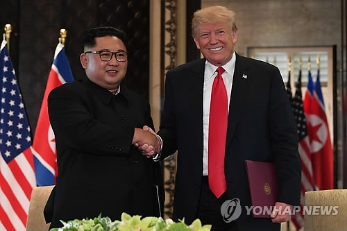 (싱가포르 AFP=연합뉴스) 역사적 첫 북미정상회담이 열린 12일(현지시간) 싱가포르 센토사 섬 카펠라호텔에서 미국 도널드 트럼프 대통령(오른쪽)과 북한 김정은 국무위원장이 공동합의문에 서명한 뒤 악수하고 있다.