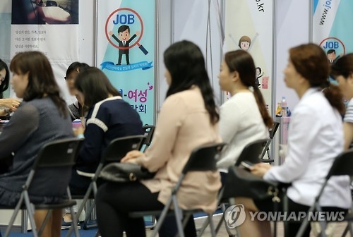 취업박람회 부스를 찾은 여성들이 면접 차례를 기다리고 있다.